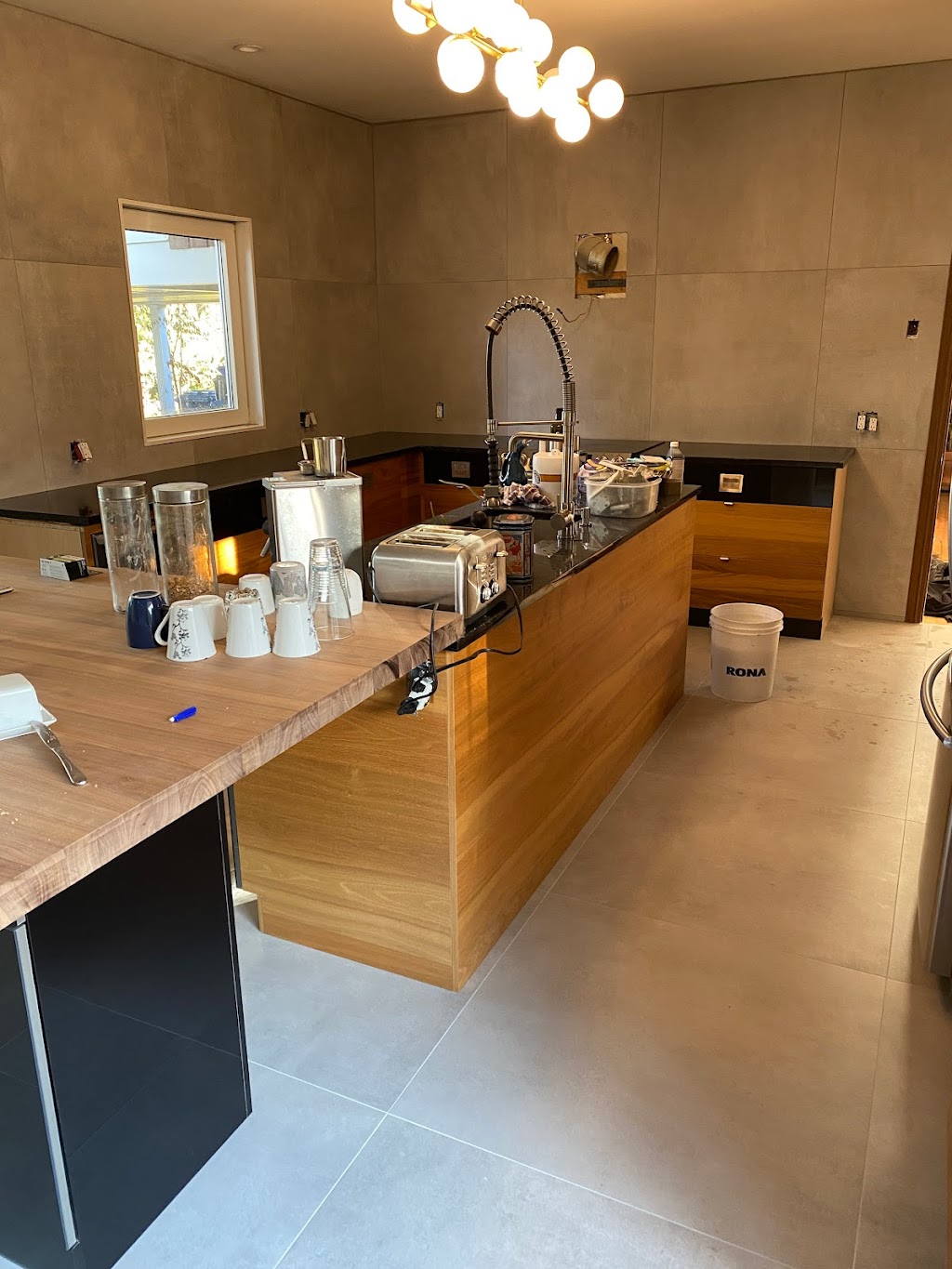 Cuisine moderne avec plancher et mur complet en céramique grand format gris mat