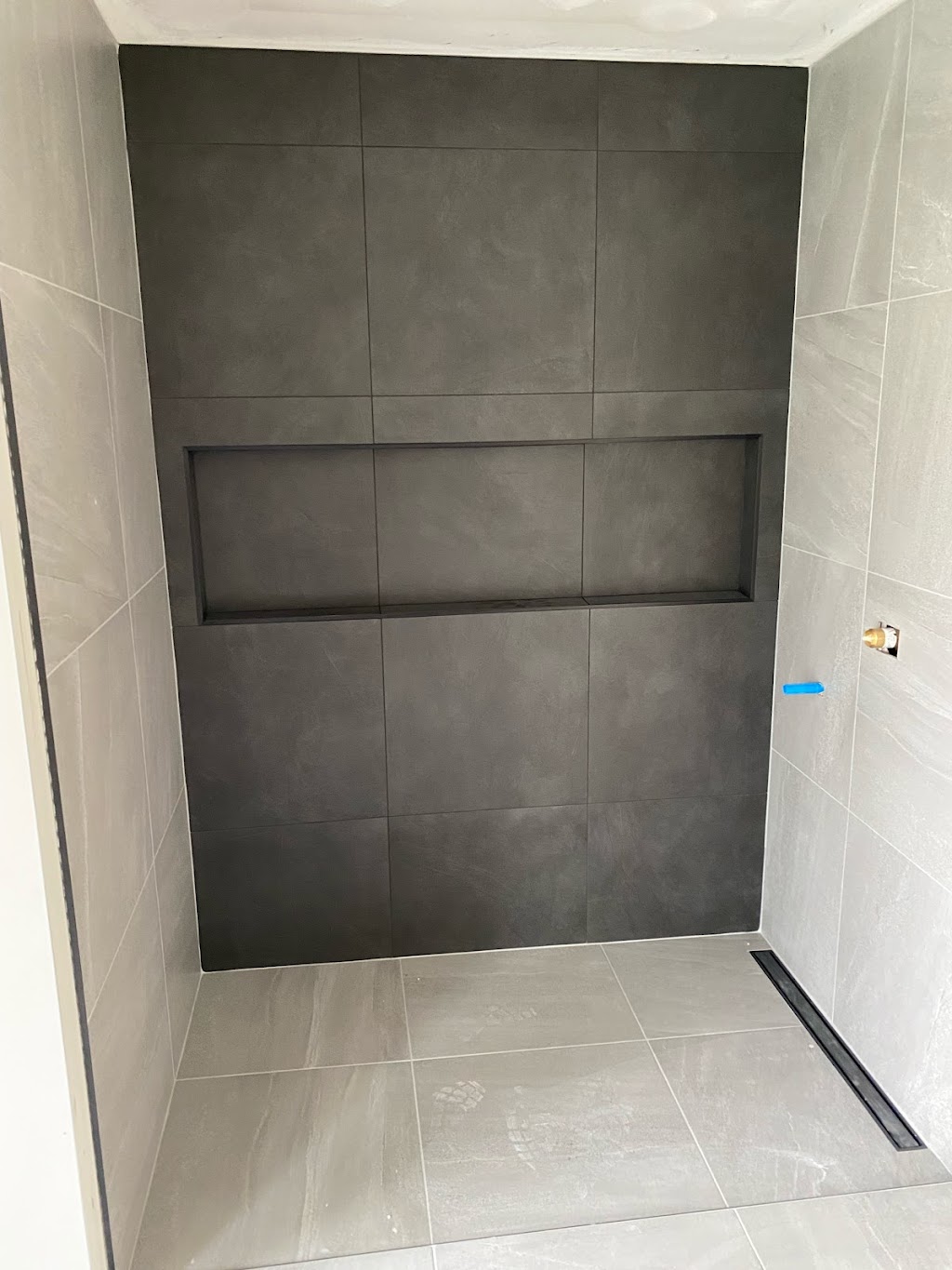 Douche walk-in anthracite et gris pâle avec grande niche horizontale et drain linéaire noir